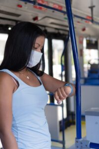 Passagère consultant les horaires affichés à un arrêt de bus avant son trajet.